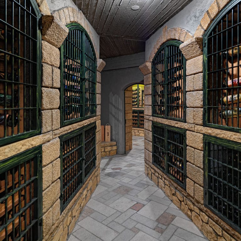 wine bottles in the wall covering with iron nettings at Domaine Costa Lazaridi Drama stone cellar